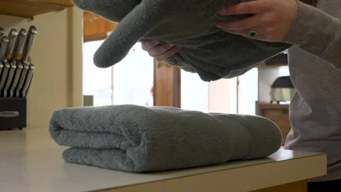 Folding soft cotton towels and placing them in a stack on the counter. Stock Footage 334333113