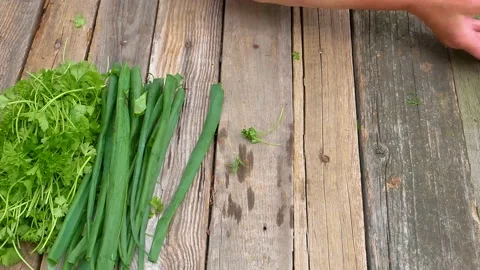Folding vegetables on a wooden table with hands. Stock Footage 155528408