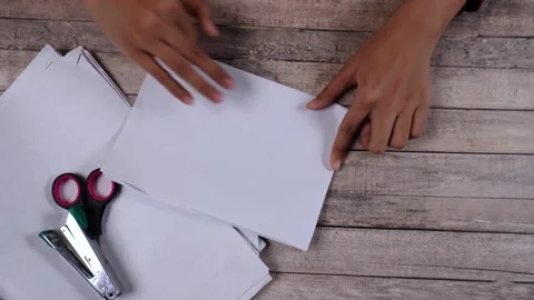 Folding white paper on the table Stock Footage 275886056