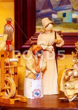 Folk style traditional handmade figures made from natural materials doing chores Stock Photos