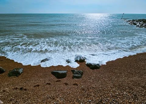 Folkestone pebble beach view of the waves hitting the pebbles Stock Photos