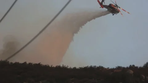 Follow Firefighter helicopter dumps tons of water onto a blazing forest, Stock Footage 226875963