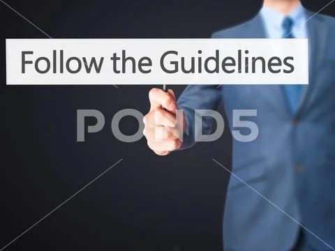 Follow the Guidelines - Businessman hand holding sign Stock Photos