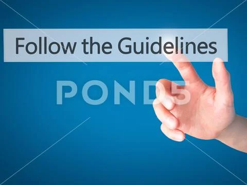 Follow the Guidelines - Hand pressing a button on blurred backgr Stock Photos