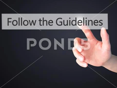 Follow the Guidelines - Hand pressing a button on blurred backgr Stock Photos