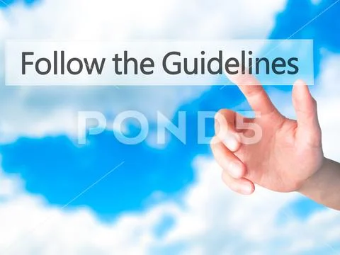 Follow the Guidelines - Hand pressing a button on blurred backgr Stock Photos