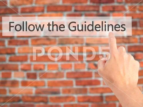 Follow the Guidelines - Hand pressing a button on blurred backgr Stock Photos
