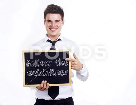 Follow the Guidelines - Young smiling businessman holding chalkboard with tex Stock Photos