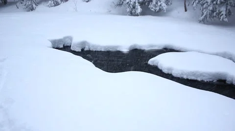 Follow pan river going under ice Stock Footage 40645763