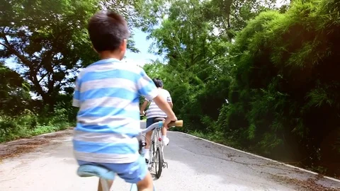 Follow scene,Slow two boy rid bicycle in the park Stock Footage 79588810