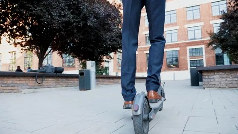 Follow shot of manager using an electric scooter to get to work Stock Footage 114749028
