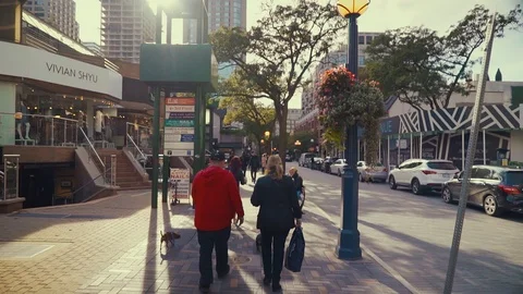 Follow shot of people walking down an interlocking brick sidewalk Stock Footage 89946559