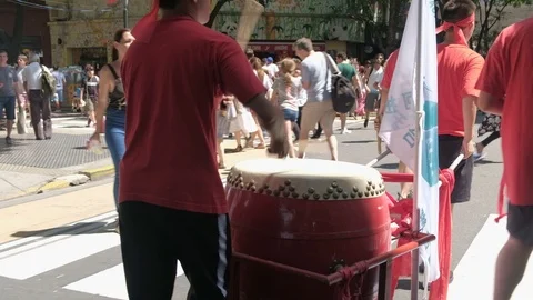 Follow shot of a percussionist playing while walking at chinese new year event Stock Footage 124023286