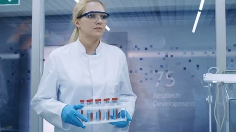 Follow up Shot of Young Female Scientist Walking with Case of Test Tubes  Stock Footage