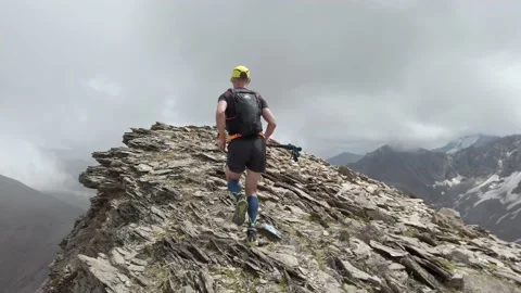 Follow view of sky-runner running high in the mountains. Video stock 138577416