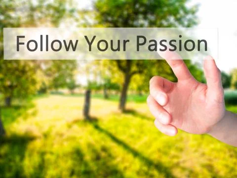 Follow Your Passion - Hand pressing a button on blurred background concept on Stock Photos