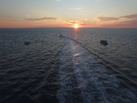 Following  boat in to golden sunset Stock Footage