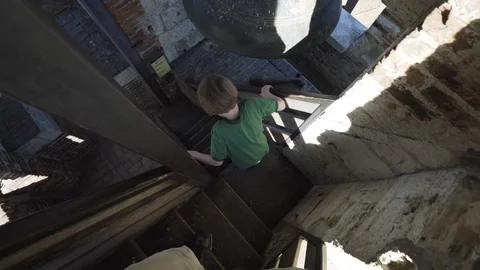 Following boy down steeps steps of Sienna Bell Tower Stock Footage 103191680