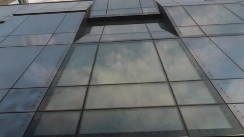 Following the cloud reflected at large glass windows of modern office building Stock Footage 268825360