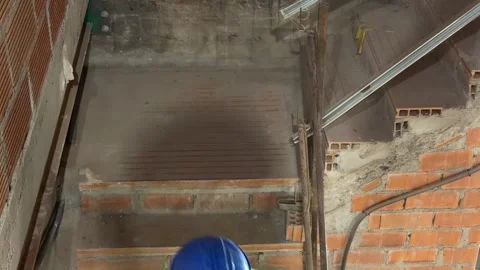 Following a construction worker with a tool belt at a building site Vidéo 336238402