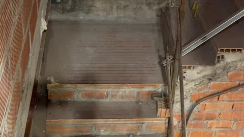 Following a construction worker with a tool belt at a building site 스톡 동영상 336238403
