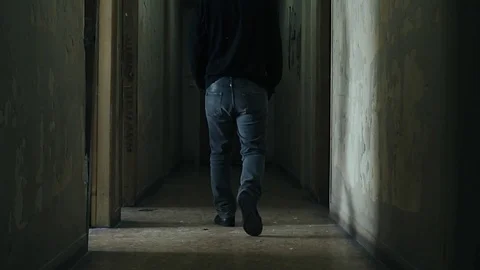 Following a dooded young man inside derelict ghetto building,slow motion Stock Footage 72555662