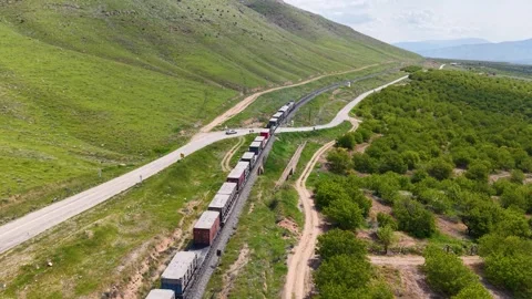 Following a Freight Train Through Apricot Orchards from Above Stock Footage 340524336