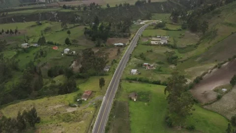 Following a highway that runs between cliffs in the andes with one white car Stock Footage 142747097