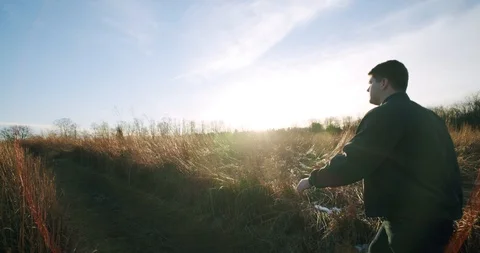 Following Man Walking Through Field During Sunset Stock Footage 122221310