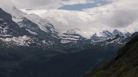 Following Paraglider with Broad Alpine View in Grindelwald Valley Stock Footage 278457769