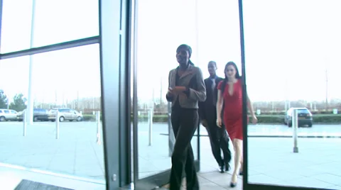 Following several colleagues as they enter a modern office building and through 스톡 동영상 32719086