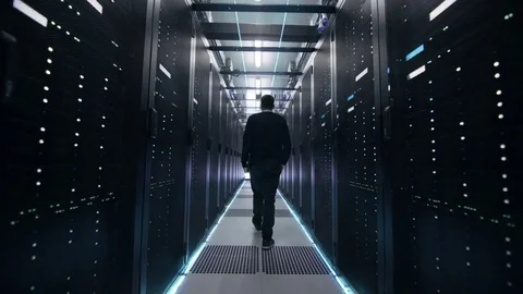 Following Shot of IT Engineer Walking Through Data Center Corridor with Rows of  動画素材 73876218