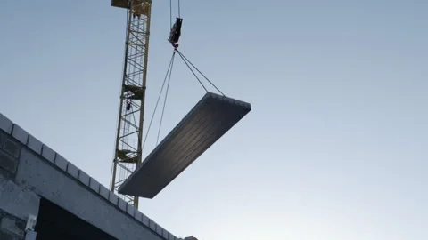 A following shot of a tower crane working at a construction site at daytime Stock Footage 248289697