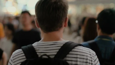 Following Shot of the Traveling Man with a Backpack Walking Through the Crowd Stock Footage