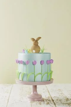 Fondant Easter cake with tulips, a bunny and Easter grass on pink cake stand, 3D Stock Illustration