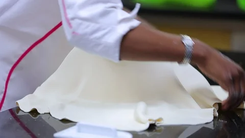 Fondant icing being applied molded to cake by baker Stock Footage 106945005