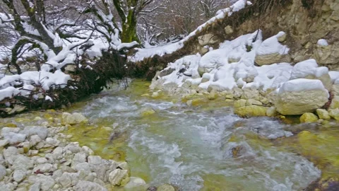 The Fondillo stream flows between the snow and the banks eroded by the water Video stock 146232762