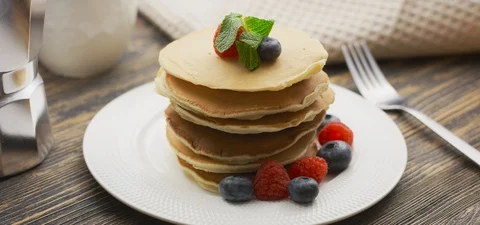 Food and Cooking Concept. Stack of pancakes with berry and warm maple syrup in Stock Footage 127892057