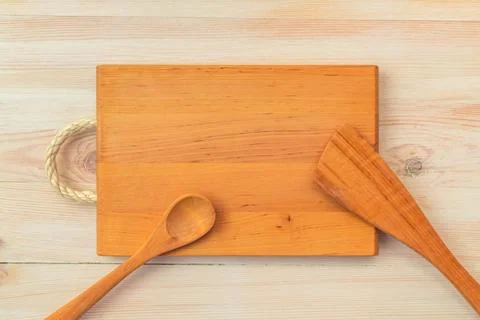 Food background. Top view of empty wooden cutting board, spoon and spatula on Stock Photos