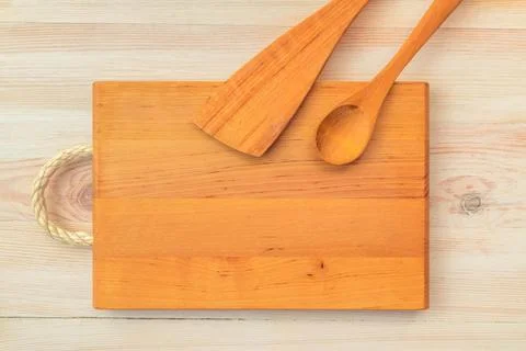 Food background. Top view of empty wooden cutting board, spoon and spatula on Stock Photos
