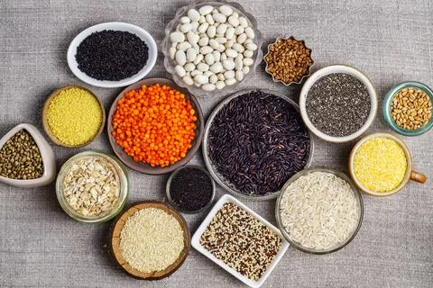 Food background of various cereals and grains in plates on a canvas Stock Photos