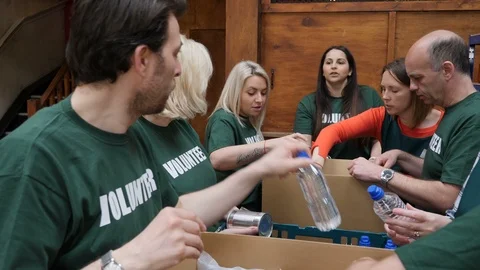Food Bank team of volunteers sorting Groceries into boxes at a Shelter. Stock Footage