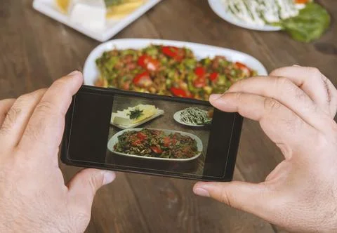 Food blogger using smartphone taking photo .Mans hands make phone photography Stock Photos