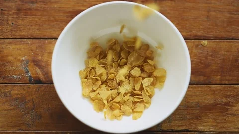 Food breakfast pouring corn flake cereal into the white bowl Stock Footage 121733962