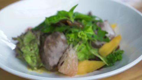 Food composition close up. Vegetable salad with meat and sauce in white plate Stock Footage 104542694