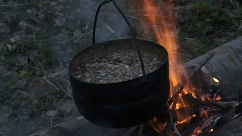 Food is cooked in black pot at the stake. Stock Footage 130445460