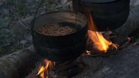 Food is cooked in two black pots at the stake. Stock Footage 130445380