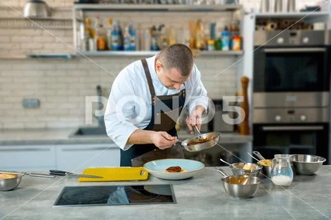 Food cooking, profession and people concept - male chef cook serving plate of Stock Photos