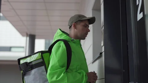 Food courier delivering order calling doorbell Stock Footage 113991653