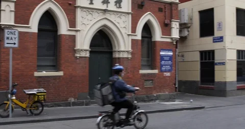 Food Delivery Driver Rides Down Middle of Road in Chinatown COVID 19 Stock Footage 128939660